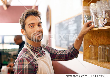 Man, barista and portrait by a shelf in coffee shop with smile for service, search and ingredients for drink. Waiter, person or small business owner in cafe with product, beans and happy for choice Man, barista and portrait by a shelf in coffee shop with smile for service, search and ingredients for drink. Waiter, person or small business owner in cafe with product, beans and happy for choice 141129890