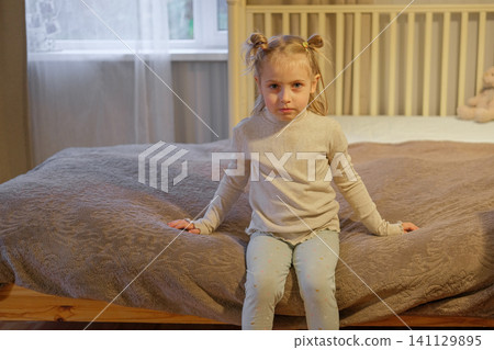 Young kid at home. Tranquil girl sitting comfortably. Content young girl relaxing peacefully with teddy bear toy. Calm happy child. Cozy bedroom portrait Caucasian blond hair child warm atmosphere Young kid at home. Tranquil girl sitting comfortably. Content young girl relaxing peacefully with teddy bear toy. Calm happy child. Cozy bedroom portrait Caucasian blond hair child warm atmosphere 141129895