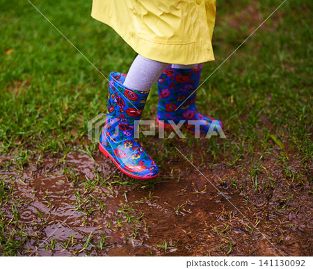 Feet, puddle and boots of kid playing in rain soil for forest, adventure or explore games in nature closeup. Earth, mud and shoes of child in woods for walking, camping or travel, holiday or vacation Feet, puddle and boots of kid playing in rain soil for forest, adventure or explore games in nature closeup. Earth, mud and shoes of child in woods for walking, camping or travel, holiday or vacation 141130092