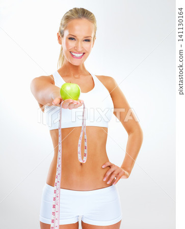 Smile, measuring tape and portrait of woman with apple for vitamin c, healthy diet or weight loss progress. Studio, happy and person with fruit for nutrition, detox and wellness on white background Smile, measuring tape and portrait of woman with apple for vitamin c, healthy diet or weight loss progress. Studio, happy and person with fruit for nutrition, detox and wellness on white background 141130164