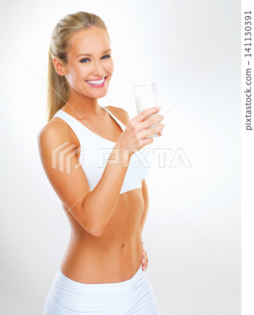 Portrait, woman and glass of milk for fitness in studio with nutrition, vitamins and calcium in white background. Organic, healthy lifestyle and wellness for diet with dairy product and mockup space Portrait, woman and glass of milk for fitness in studio with nutrition, vitamins and calcium in white background. Organic, healthy lifestyle and wellness for diet with dairy product and mockup space 141130391