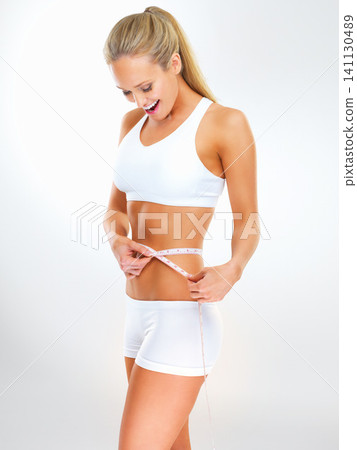 Woman, tape measure and lose weight results in studio for healthy progress with workout training, nutrition or white background. Female person, excited and diet wellness for target, goals or mockup Woman, tape measure and lose weight results in studio for healthy progress with workout training, nutrition or white background. Female person, excited and diet wellness for target, goals or mockup 141130489