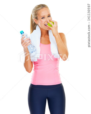 Woman, portrait and studio with apple for fitness with water for hydration and healthy diet with exercise for slim body. Person, fruit for snack and bottle with nutrition and happy for wellness Woman, portrait and studio with apple for fitness with water for hydration and healthy diet with exercise for slim body. Person, fruit for snack and bottle with nutrition and happy for wellness 141130597