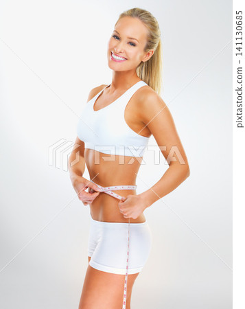 Woman, portrait and tape measure for lose weight in studio or exercise training with nutrition diet, exercise or white background. Female person, face and healthy results, confidence or mockup space 141130685