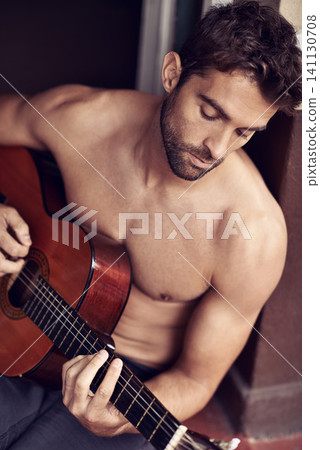 Guitar, play or man in home for music, performance or entertainment with sound, rhythm or talent. Learning solo, topless artist or creative male musician with an instrument for practice routine alone Guitar, play or man in home for music, performance or entertainment with sound, rhythm or talent. Learning solo, topless artist or creative male musician with an instrument for practice routine alone 141130708