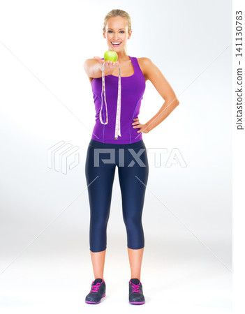 Woman, portrait and tape measure in studio with apple for healthy body, fitness transformation and wellness. Happy, person and fruit to lose weight, antioxidant and clean eating on white background Woman, portrait and tape measure in studio with apple for healthy body, fitness transformation and wellness. Happy, person and fruit to lose weight, antioxidant and clean eating on white background 141130783