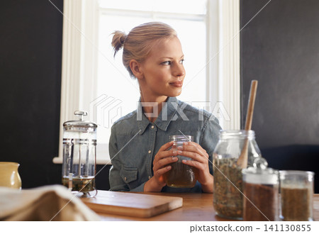 Woman, thinking and herbal tea to relax in home and warm beverage of herbs mixture for health. Happy, designer and creative idea for dried leaves in plunger and wellness for detox drink in mason jar Woman, thinking and herbal tea to relax in home and warm beverage of herbs mixture for health. Happy, designer and creative idea for dried leaves in plunger and wellness for detox drink in mason jar 141130855