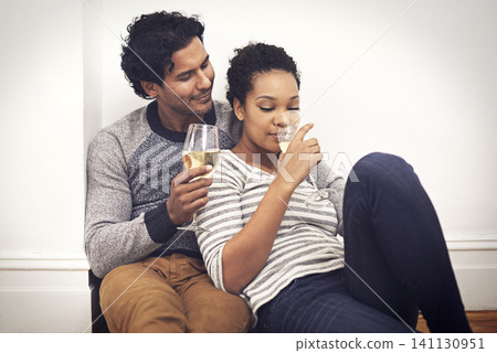 Couple, floor and wine for celebration and embrace in home, smile and proud of marriage and commitment. People, milestone and drinking in living room on weekend, support and alcohol for relationship Couple, floor and wine for celebration and embrace in home, smile and proud of marriage and commitment. People, milestone and drinking in living room on weekend, support and alcohol for relationship 141130951