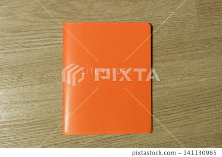 Multicolored Literature exercise book over wooden desktop background, close up. Education and reading concept. Orange bright colorful textbook. Flat Lay. Back to school. Multicolored Literature exercise book over wooden desktop background, close up. Education and reading concept. Orange bright colorful textbook. Flat Lay. Back to school. 141130965