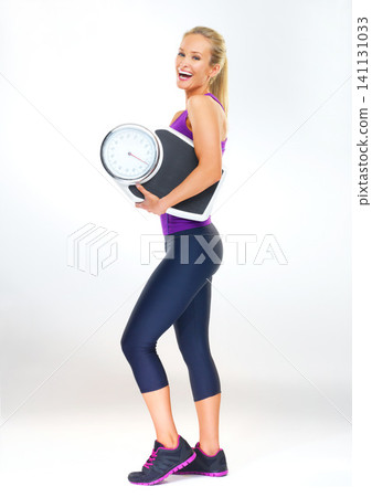 Woman, portrait and scale in studio for results, smile and excited for progress of diet or detox. Female person, laugh and happy for calories burned target or goals, wellness and white background Woman, portrait and scale in studio for results, smile and excited for progress of diet or detox. Female person, laugh and happy for calories burned target or goals, wellness and white background 141131033
