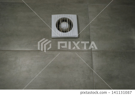Home vent grille for air purification, circulation. Forced ventilation in wall under ceiling. Bathroom ventilation fan in modern apartment photo. Industrial vents. Square ventilation cap. Vents pipes. Home vent grille for air purification, circulation. Forced ventilation in wall under ceiling. Bathroom ventilation fan in modern apartment photo. Industrial vents. Square ventilation cap. Vents pipes. 141131087