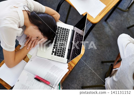 Laptop, education and woman student sleeping on desk in class with exhaustion or fatigue from above. Computer, burnout or tired and young person asleep in school classroom with books for study Laptop, education and woman student sleeping on desk in class with exhaustion or fatigue from above. Computer, burnout or tired and young person asleep in school classroom with books for study 141131152