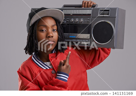 Black child, serious and portrait with radio and hand sign for hip hop, rap and swag with cool clothes in studio. Young, teen and boombox with gangster style and fashion and kid with grey background Black child, serious and portrait with radio and hand sign for hip hop, rap and swag with cool clothes in studio. Young, teen and boombox with gangster style and fashion and kid with grey background 141131169