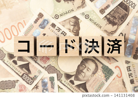 A block with "Code Payment" written on it and lots of 10,000 yen bills A block with "Code Payment" written on it and lots of 10,000 yen bills 141131408