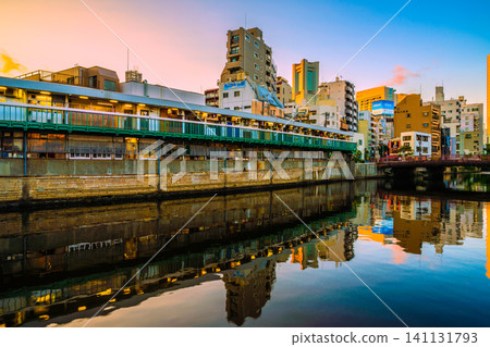 日本橫濱城市景觀:橫濱市野毛區。口琴巷,酒吧區。背景中可見橫濱地標塔和富士軟影城。 日本橫濱城市景觀:橫濱市野毛區。口琴巷,酒吧區。背景中可見橫濱地標塔和富士軟影城。 141131793