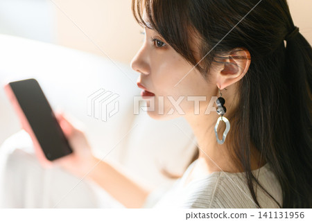 A woman looking at a smartphone 141131956