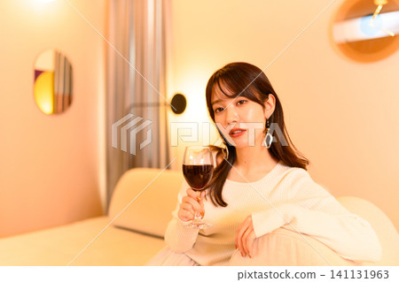一位女士舉著一杯葡萄酒 141131963