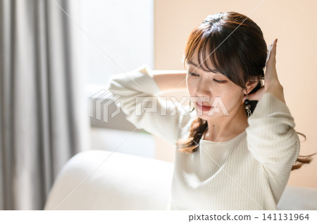 A woman tying her hair A woman tying her hair 141131964
