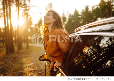A traveler enjoys a sunny day from the car window. Travel concept. Active lifestyle. A traveler enjoys a sunny day from the car window. Travel concept. Active lifestyle. 141132239