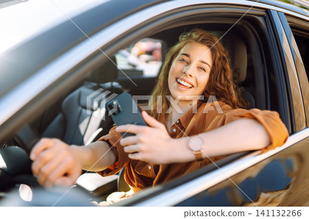 A young woman uses a mobile phone to navigate in the city, pay for parking. Business concept. A young woman uses a mobile phone to navigate in the city, pay for parking. Business concept. 141132266