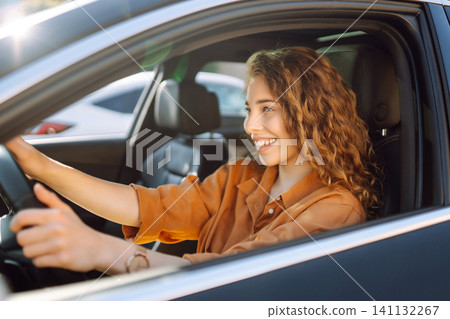 Emotional woman drives a car. The concept of fast movement, traveling by car. Emotional woman drives a car. The concept of fast movement, traveling by car. 141132267