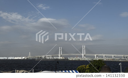 The Yokohama Bay Bridge spanning Yokohama Port and the harbor scenery against a clear blue sky. 141132330