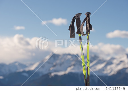 Cross Country Ski Poles Against Snowy Mountain Peaks with Copy Space Cross Country Ski Poles Against Snowy Mountain Peaks with Copy Space 141132649