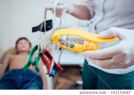 Doctor with electrocardiogram equipment making cardiogram test Doctor with electrocardiogram equipment making cardiogram test 141132687
