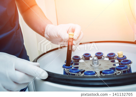 Platelet-Rich plasma preparation. Tube with blood in hands. Centrifuge. Platelet-Rich plasma preparation. Tube with blood in hands. Centrifuge. 141132705