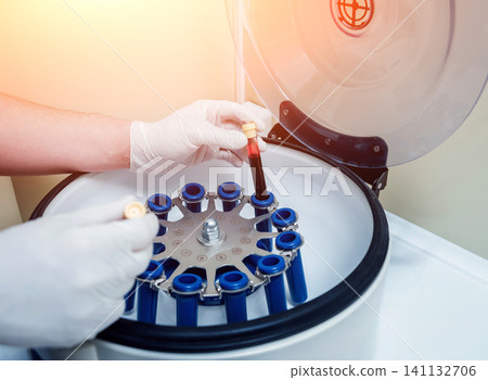 Platelet-Rich plasma preparation. Tube with blood in hands. Centrifuge. Platelet-Rich plasma preparation. Tube with blood in hands. Centrifuge. 141132706
