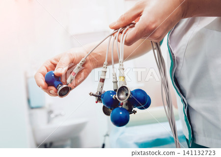 Doctor with electrocardiogram equipment making cardiogram test Doctor with electrocardiogram equipment making cardiogram test 141132723
