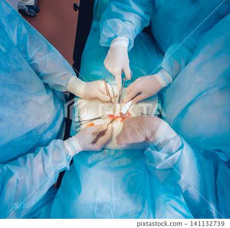 Group of surgeons in operating room with surgery equipment. Group of surgeons in operating room with surgery equipment. 141132739