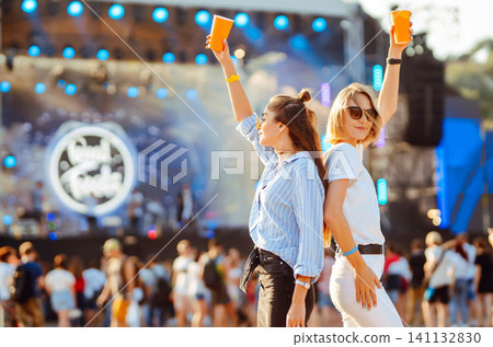 Two woman having great time at music festival. Girlfriends rinking beer at Beach party. Lifestyle. Two woman having great time at music festival. Girlfriends rinking beer at Beach party. Lifestyle. 141132830