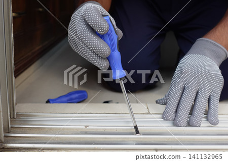 Fixing a door with care and precision during daylight hours Fixing a door with care and precision during daylight hours 141132965
