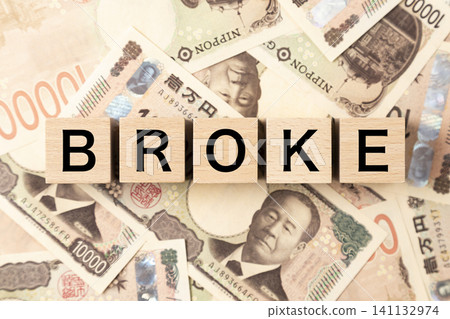 A block labeled "BROKE" and lots of 10,000 yen bills A block labeled "BROKE" and lots of 10,000 yen bills 141132974