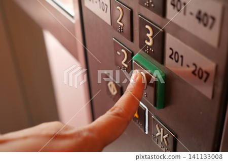 Pressing the elevator button in a bustling building Pressing the elevator button in a bustling building 141133008