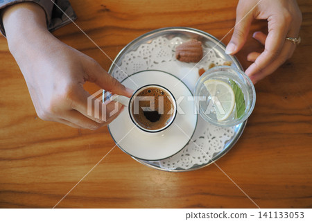 Enjoying turkish coffee and refreshing drink at a cozy cafe table Enjoying turkish coffee and refreshing drink at a cozy cafe table 141133053