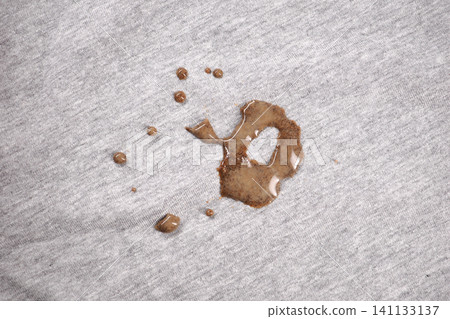 Spilled chocolate creating a mess on gray fabric Spilled chocolate creating a mess on gray fabric 141133137