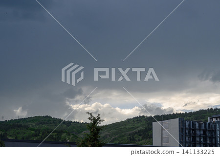 Development of thunderstorm clouds over hilly landscape cumulonimbus clouds with rain Development of thunderstorm clouds over hilly landscape cumulonimbus clouds with rain 141133225