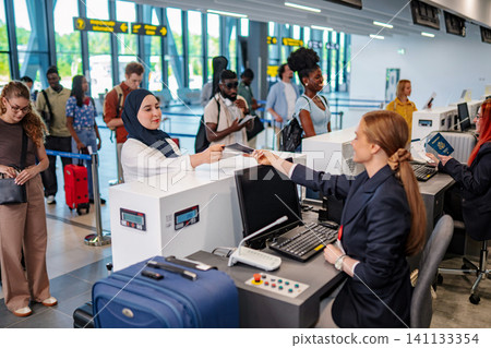 Travelers checking in at airport with diverse group queueing Travelers checking in at airport with diverse group queueing 141133354