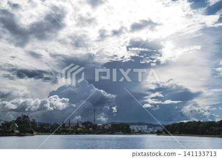A large cloud is in the sky above a body of water 141133713