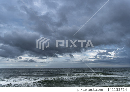 The sky is cloudy and the ocean is calm The sky is cloudy and the ocean is calm 141133714