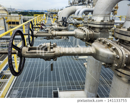 A row of valves are on a metal grate A row of valves are on a metal grate 141133755