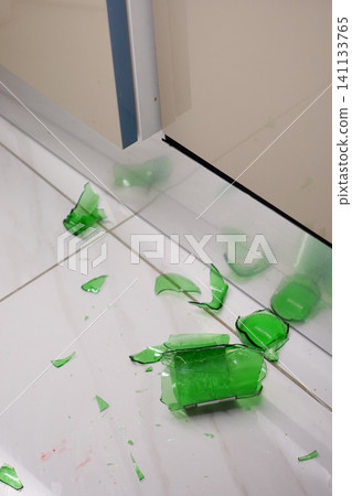 Broken glass scattered on the kitchen floor after a fall 141133765