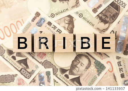 A block with "BRIBE" written on it and lots of 10,000 yen bills. A block with "BRIBE" written on it and lots of 10,000 yen bills. 141133937