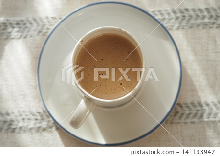 Enjoying a cup of coffee in morning light Enjoying a cup of coffee in morning light 141133947