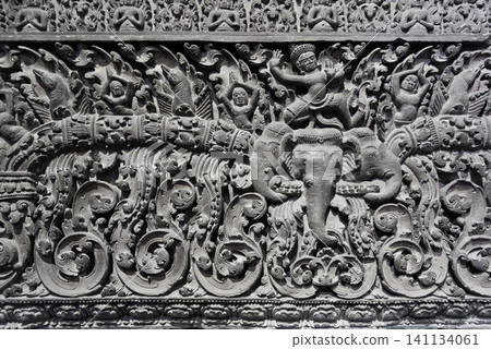 A wall with a lot of detail and a man riding an elephant A wall with a lot of detail and a man riding an elephant 141134061
