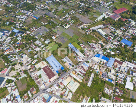 Drone aerial view of a suburban area with residential neighborhoods and agricultural fields Drone aerial view of a suburban area with residential neighborhoods and agricultural fields 141134136