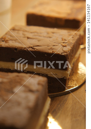 Delicious chocolate dessert squares on a wooden table Delicious chocolate dessert squares on a wooden table 141134167
