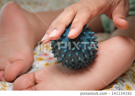 Foot massage technique using a spiky massage ball Foot massage technique using a spiky massage ball 141134192